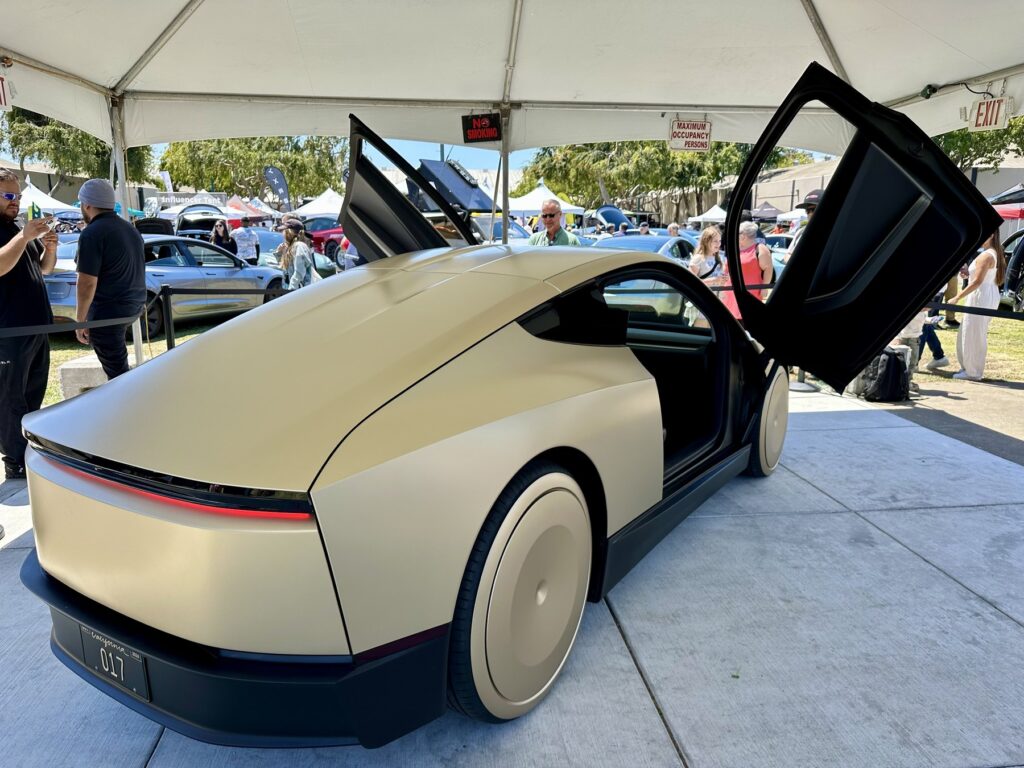 Tesla Cybercab with both butterfly doors open, showing a two-seat cabin